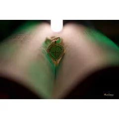 A creative and symbolic shot of a heart-shaped pendant resting on a book, representing a new chapter in a love story.