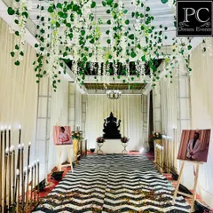 A modern and chic wedding walkway. I used a ceiling of hanging greenery, a bold black-and-white chevron runner, and personalized photo easels to create a stylish and personal entrance gallery.
