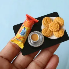 A close-up of a Marie Gold biscuit platter with a tiny cup of chai, a classic combination.