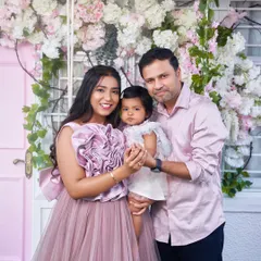 A picture-perfect family moment in front of our pink door studio setup. The mother is wearing our mauve Bloom gown.