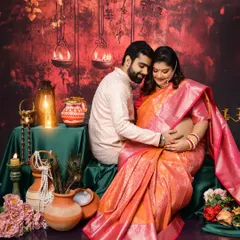 An intimate moment from a traditional maternity session. The couple is seated amidst earthen pots and diyas, with the mom-to-be glowing in a beautiful silk saree.