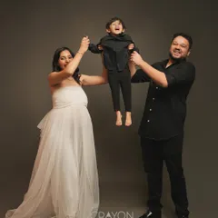 Pure joy and excitement for the new arrival. The parents playfully lift their son, his laughter filling the studio. This image captures the happy energy of a growing family.