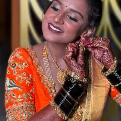 A candid moment of happiness. I love capturing these final touches, where the whole look comes together. This close-up shows the detailed eye makeup, the rich lip color, and the intricate henna, all part of the complete bridal story.