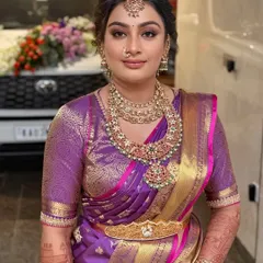 A vision of tradition reimagined for this gorgeous South Indian bride. The makeup features a soft smokey eye and a neutral lip, allowing her magnificent temple jewellery and purple Kanjivaram to shine.
