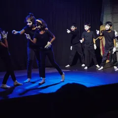A group of children performing a mime act, using expressive body language and movement to tell a story without words.