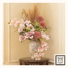 This beautiful arrangement of pink orchids and chrysanthemums adds a soft, romantic touch to this side table. The lifelike quality of the flowers ensures they brighten the room all year round.