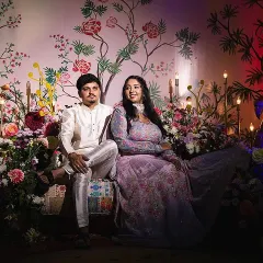 A couple seated amidst a vibrant and artistic Mehendi function setup in Yelahanka. As I also handle event decor, I know the best angles to photograph the setup and make both the couple and the background look spectacular.