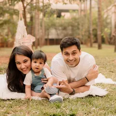 A classic family portrait, lying on the grass together. The smiles are genuine and the love is clear in this beautiful outdoor shot.