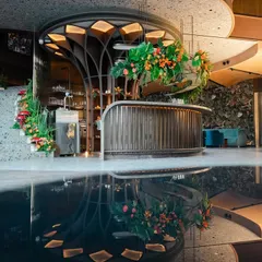 Welcome to the 'Citrus Safari'. We transformed this reception venue into a vibrant jungle with a custom-designed bar, tropical florals, and a stunning water reflection that doubled the magic.