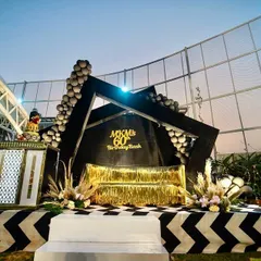 A 60th birthday bash with a bold and modern black, white, and gold theme. I designed this geometric stage with a custom backdrop, a gold fringe couch, and chevron-patterned flooring to create a super chic and glamorous photo-op area.