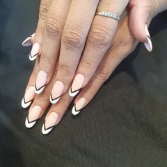 A sharp and graphic French manicure. This design uses a V-shape, or chevron, tip in crisp white with a black outline for a bold and modern twist on the classic.