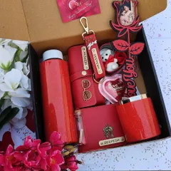A view of the sparkling red Valentine's hamper packed and ready to gift. You can customize the flask, mug, and leather products with a name, and the rose stick with a picture.
