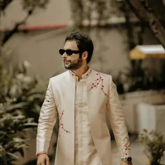 The dapper groom. This walking shot captures his confident stride and the stylish details of his embroidered jacket, making for a sharp and modern portrait.