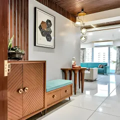 We designed this foyer with a custom shoe cabinet featuring a chevron pattern on the doors. The unit is paired with a matching cushioned bench, providing a practical and stylish spot to sit and remove shoes.