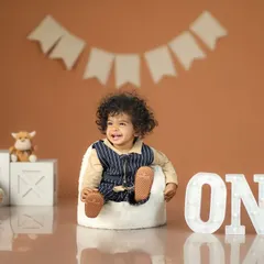 Look at that happy smile! Celebrating one whole year of giggles and joy is such a special milestone. I love capturing the big "ONE" moment for families to cherish.