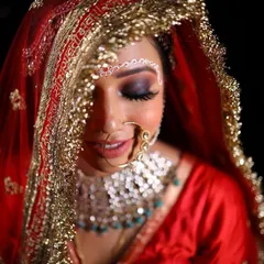 A beautiful close-up of the bride's face, partially covered by her dupatta. The smokey eye and flawless skin create a look of pure elegance.