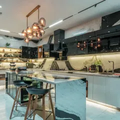This kitchen is conceived as the heart of the home, blending function with high-end aesthetics. We used bookmatched Panda marble for the island and backsplash, complemented by sleek, high-gloss cabinetry and layered lighting, including a statement pendant fixture.