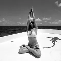 Sun, sea, and a little asana. A moment of peace and connection on a boat, finding my center with a seated lotus pose.