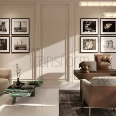 A workspace designed to elevate creativity and style. The room combines a comfortable seating area with a functional desk, framed by classic wall paneling and a gallery of black-and-white photographs for a personal touch.