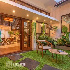 This indoor-outdoor space is enhanced by lush greenery and simple, elegant furniture. The hanging plants and natural wood tones create a seamless connection to the outdoors.