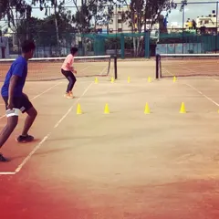 Two players execute a fast-paced agility drill, weaving through cones to improve their reaction time and change-of-direction speed.