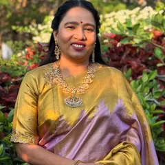 The mother looks absolutely graceful in her gold and lavender Kanchipuram silk saree. Her makeup is classic and elegant, enhancing her features beautifully.