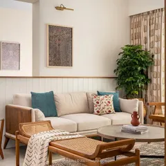 We love to blend textures to create warm, inviting living spaces. In the 'Palaash' project, we used a mix of wood, rattan, and soft fabrics to craft a contemporary yet earthy feel. The curved half-wall and custom TV unit with dual-side access add a layer of bespoke functionality and visual softness to the room.