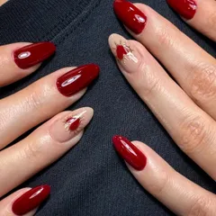 A romantic and classy design. This set of cherry red nails is elevated by a hand-painted heart with isolated golden chrome detailing on the accent finger.