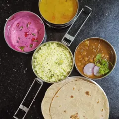This is a classic meal combination that brings pure comfort. It includes ghee rice, flavorful chole, simple dal, two warm rotis, and a refreshing beetroot raita topped with pomegranate seeds.