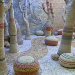 This installation for the 'Hope You're Well' trend uses soft, crocheted forms to create a comforting, gentle landscape. The tree-like sculptures and pebble-like poufs, all rendered in soothing colors, build a space that speaks of empathy, acceptance, and wellbeing.