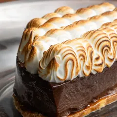 My Hazelnut Chocolate dessert is pure decadence. It features a crisp praline base, rich dark chocolate mousse, and a beautifully torched soft meringue topping. It's a dessert made for special moments.