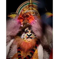 A striking portrait of a Kathakali artist performing as Narasimha. The detailed makeup, costume, and intense expression are captured with dramatic lighting.