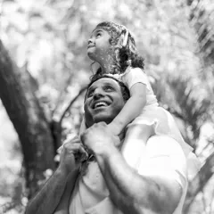 The love a father has for his daughter is so powerful. This black and white image, looking up through the trees, captures a moment of pure joy and wonder.