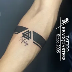 A modern armband design that combines solid black bands with a Valknut symbol and the name "Mickey" in fine script.