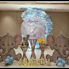 Agastya's first birthday was celebrated with this adorable baby elephant theme. The decor includes large, cute elephant cutouts, a blue and silver balloon arch, and light-up letters spelling out his name.