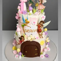 We built a tiny, enchanting world for this two-tiered fairy house cake. It features multiple hand-painted fairy figurines, sculpted mushrooms, and a detailed wooden door, all designed to capture the magic of a childhood storybook.