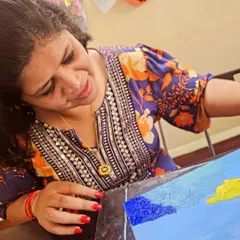 The artist at work. A close-up of a student fully engaged in the creative process during our palette knife painting workshop.
