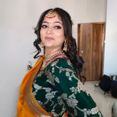 A beautiful look for a Haldi or Mandap ceremony. The makeup is kept fresh and glowing, with pink tones on the eyes and lips to complement the yellow and green saree.