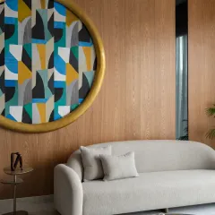 This magnificent six-foot round painting is the main attraction in the drawing room of The House of Dancing Screens. The room's neutral decor provides a sophisticated background, allowing the colorful, geometric artwork to make a bold statement.