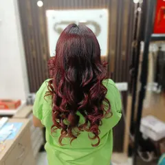 A full head of rich, vibrant red hair styled into beautiful, bouncy curls. This is a statement color that exudes confidence.