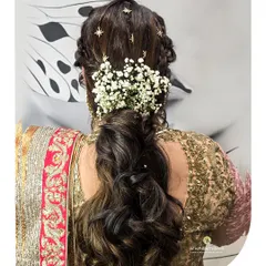 Our hairstyling for traditional wear is all about the details. This braided ponytail with fresh flowers and star clips is a perfect example of festive hair artistry.