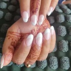 This is a classic French manicure with a slightly thicker white tip on oval-shaped nails. It's a beautiful look that works well for both daily wear and special events.