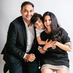 A joyful and candid moment from a studio family photoshoot. The son's happy hug from behind perfectly captures the playful spirit of this family.