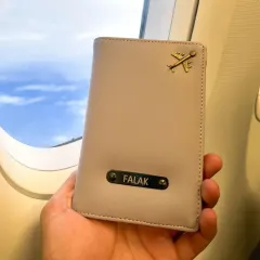 Travel in style with a personalized passport holder. This one is shown with a name and an airplane charm, making it the perfect accessory for your next trip.