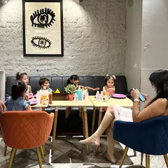A group of children and a parent enjoying snacks and drinks at a table in our café. It's a great spot to refuel after a fun play session.