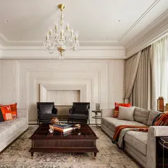 In this living room, we integrated the fireplace with a continuous expanse of white Ondulutu stone, creating a seamless and monumental feature wall. The neutral palette is punctuated by luxurious textures and carefully selected furniture, achieving a balance of classic grace and contemporary comfort.