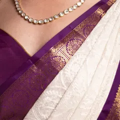 A close-up view of the pure gold zari border meeting the delicate, handcrafted Chikankari work on the body of the saree.
