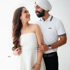 The look of love. This couple shares a joyful, candid moment in our light and airy setup, with their matching white outfits adding to the fresh and clean aesthetic.