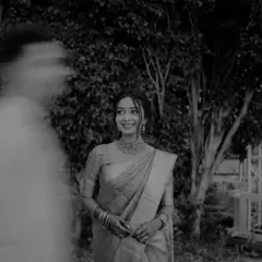 An artistic black and white bridal portrait with a sense of movement and mystery, created by a blurred figure in the foreground.