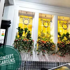 This is the exterior view of a restaurant project. We installed beautiful artificial window boxes overflowing with colorful bougainvillea, creating charming curb appeal that invites customers in.